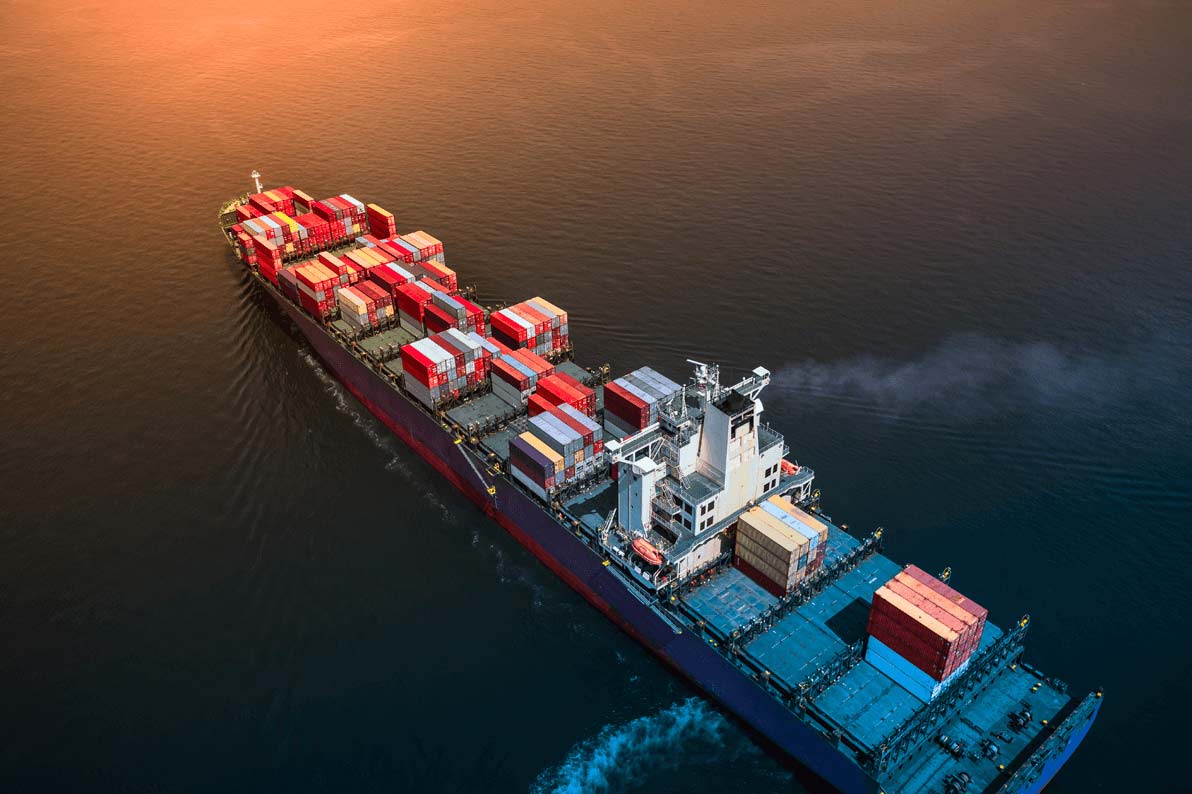 Cargo ship sailing out at sea during the sunset Cargo ship sailing out at sea during the sunset