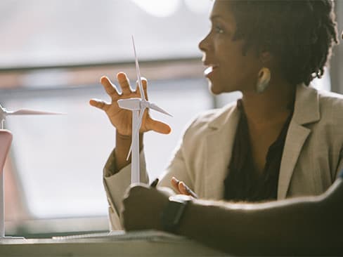 Person gesturing to model wind turbine